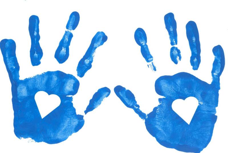 Picture of open Hand prints in blue finger paint with hearts cut out of the palms